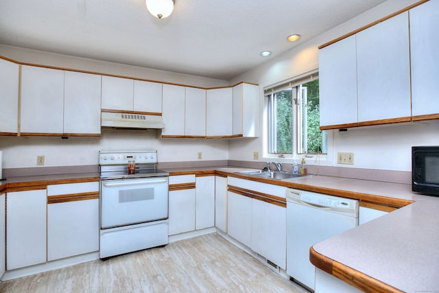 kitchen with white cabinets, sink, light hardwood / wood-style floors, and white appliances