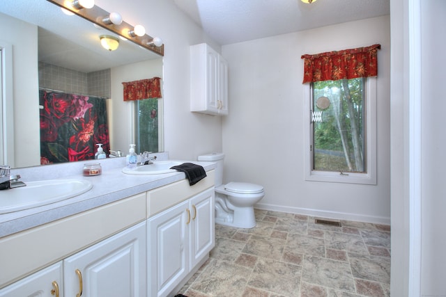 bathroom with a shower with shower curtain, a textured ceiling, vanity, and toilet