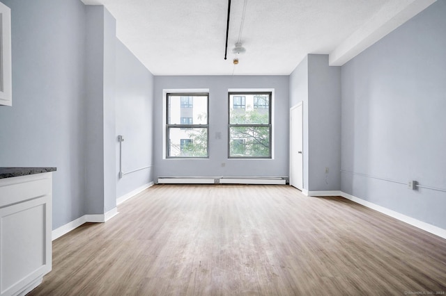 interior space featuring light wood-type flooring, baseboards, and a baseboard heating unit