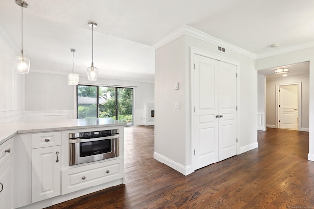 kitchen with white cabinetry, stainless steel oven, crown molding, decorative light fixtures, and dark hardwood / wood-style floors