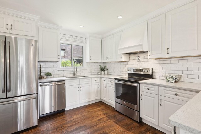 kitchen featuring white cabinetry, sink, dark wood-type flooring, custom range hood, and appliances with stainless steel finishes