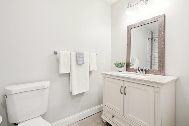 bathroom with vanity, toilet, and hardwood / wood-style floors