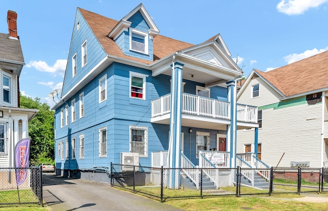 view of front of home featuring a fenced front yard, a gate, a porch, and a balcony