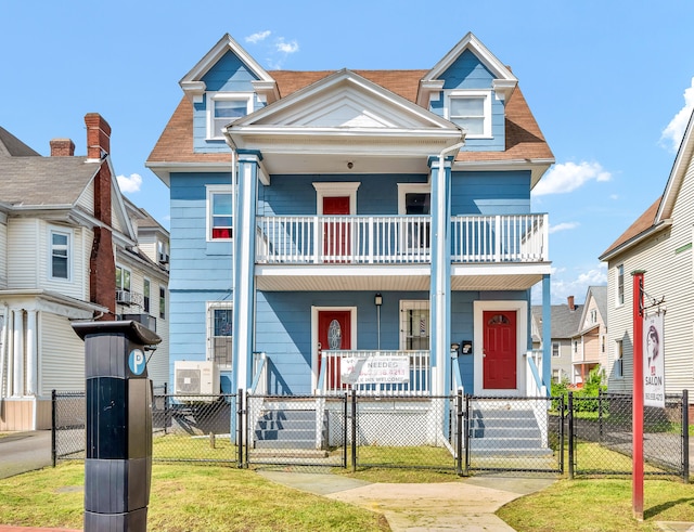 view of front of property with a balcony, a front yard, and covered porch