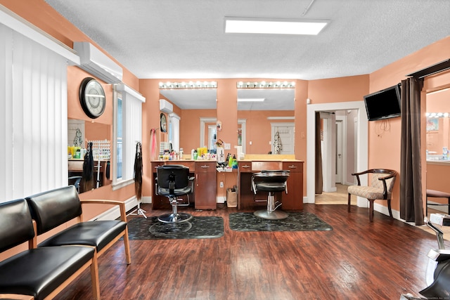 office featuring a textured ceiling, dark wood-type flooring, and a wall mounted air conditioner