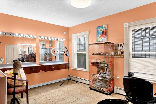 interior space with baseboards, light tile patterned flooring, a textured ceiling, and baseboard heating