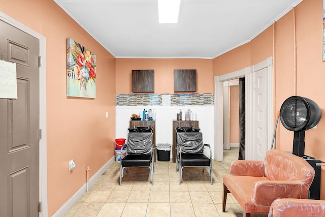 sitting room featuring light tile patterned flooring, crown molding, and baseboards