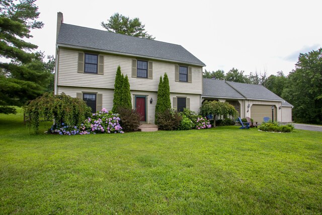 colonial house with a garage and a front lawn