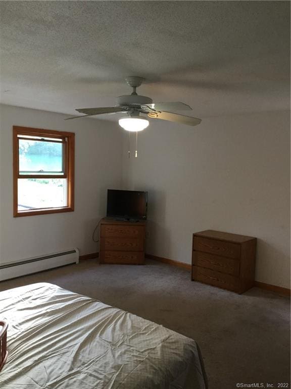 carpeted bedroom with a textured ceiling, a baseboard radiator, and ceiling fan