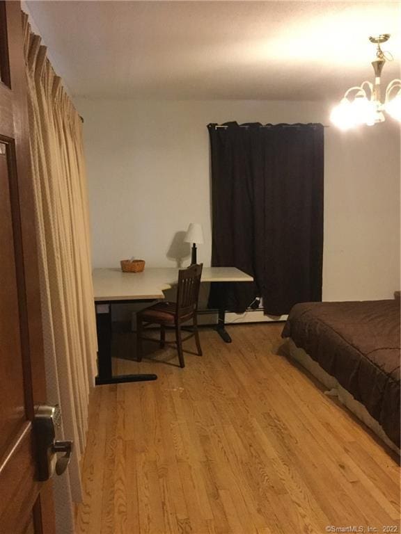 bedroom featuring a notable chandelier and light hardwood / wood-style flooring