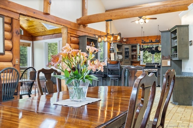 dining area with vaulted ceiling with beams, ceiling fan, and rustic walls