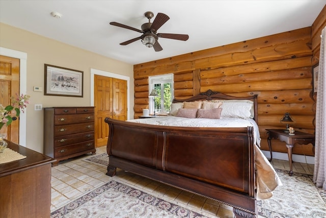 bedroom featuring ceiling fan and log walls