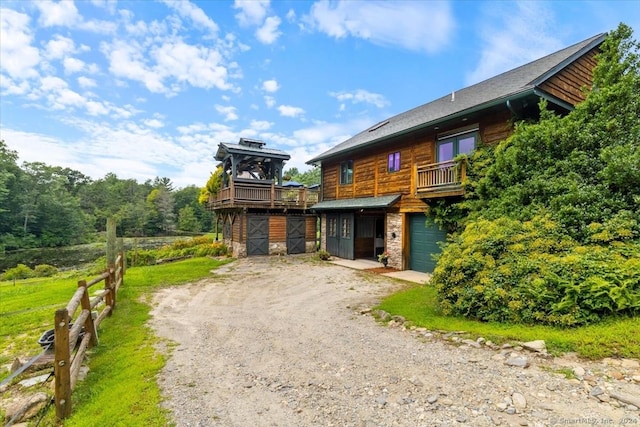 584 Prospect St, Woodstock, CT 06281 - view of front facade featuring a garage, a wooden deck, driveway, and stone siding