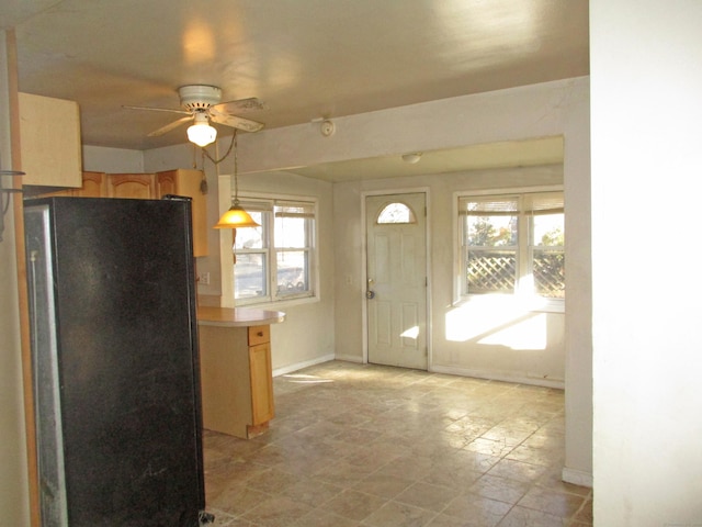 kitchen featuring black refrigerator, pendant lighting, plenty of natural light, and ceiling fan