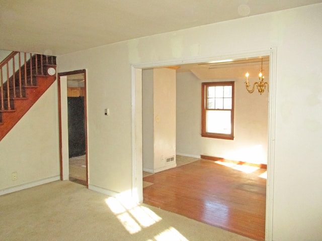 unfurnished room featuring hardwood / wood-style floors and an inviting chandelier