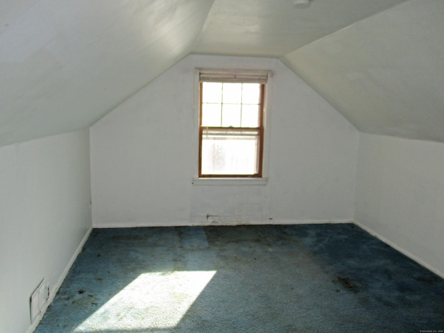 bonus room featuring vaulted ceiling and dark carpet