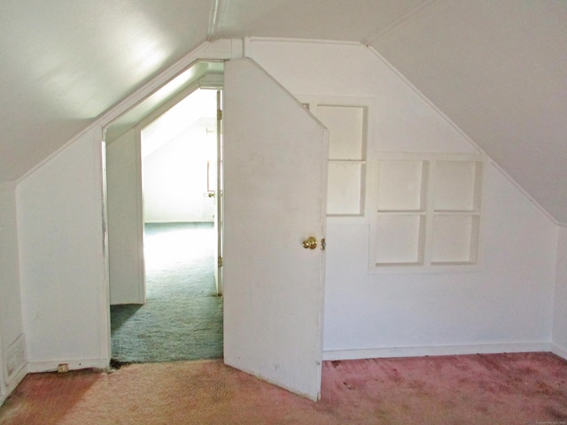 additional living space featuring light carpet and lofted ceiling