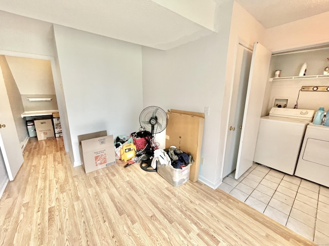 laundry area with independent washer and dryer and light wood-type flooring