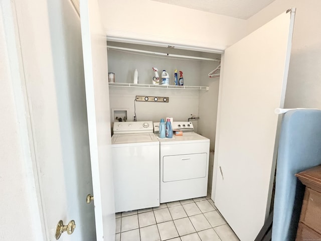 laundry area featuring washing machine and dryer and light tile patterned flooring