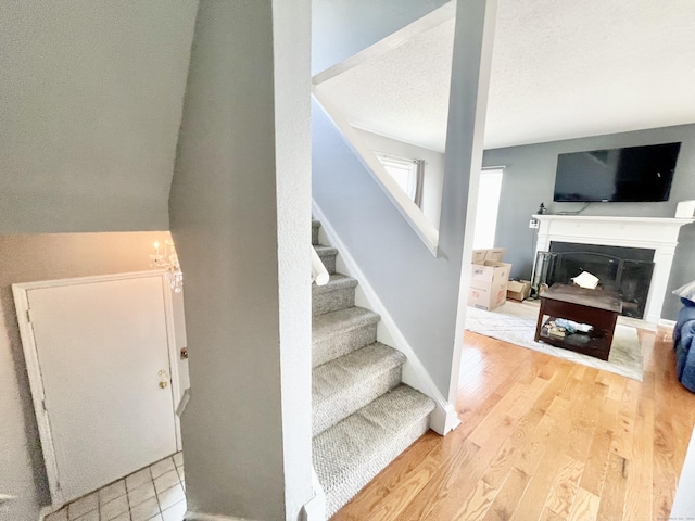 stairway featuring wood-type flooring and a textured ceiling