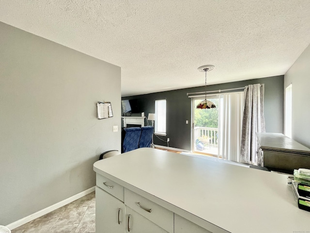 kitchen featuring pendant lighting, a textured ceiling, and light tile patterned flooring