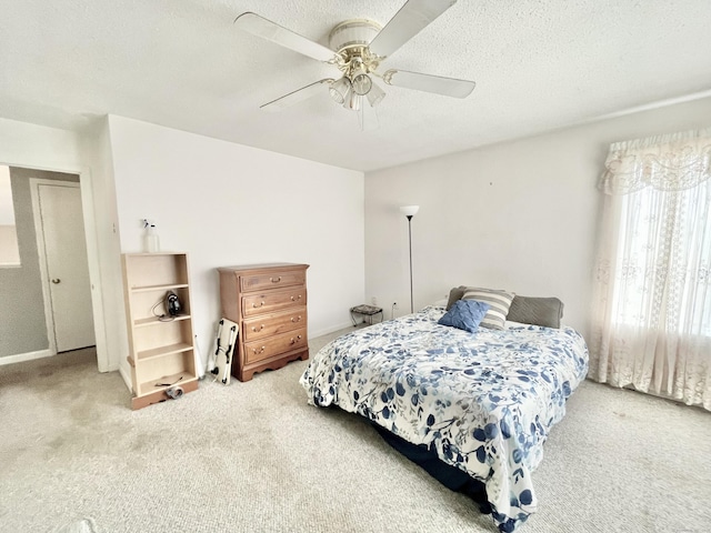 bedroom featuring ceiling fan, light carpet, and a textured ceiling