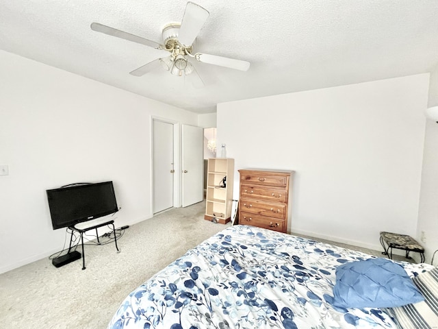 carpeted bedroom with ceiling fan and a textured ceiling