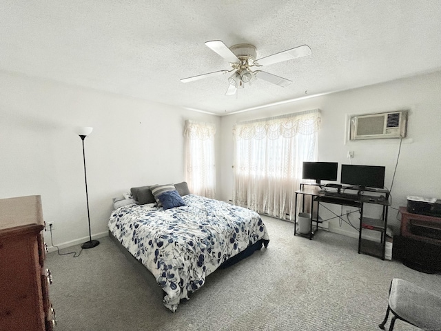 bedroom with ceiling fan, a wall unit AC, a textured ceiling, and carpet flooring