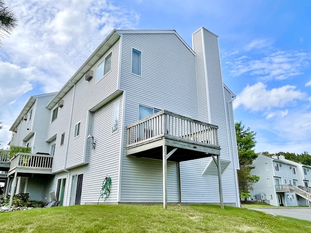 rear view of property with a deck and a lawn