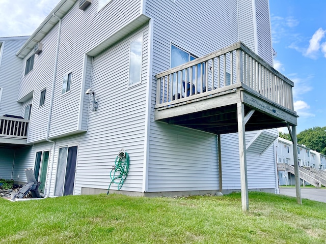 view of side of property with a wooden deck and a yard