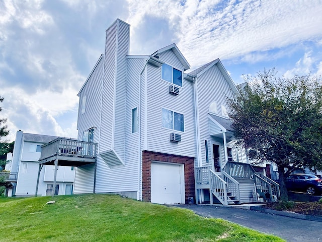 view of home's exterior featuring a garage, a yard, and a wall mounted air conditioner