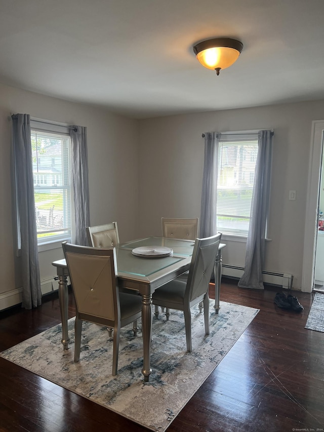 dining space with a baseboard radiator, dark hardwood / wood-style floors, and a healthy amount of sunlight