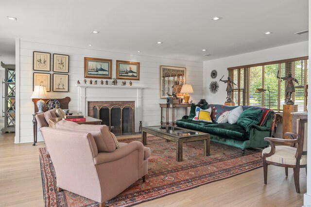 living room with wood walls and light hardwood / wood-style flooring