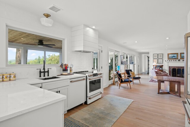 kitchen featuring ceiling fan, sink, white appliances, white cabinetry, and light wood-type flooring