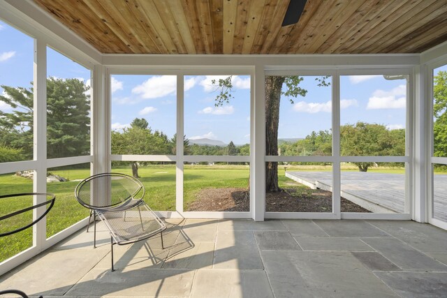 unfurnished sunroom featuring a wealth of natural light and wooden ceiling