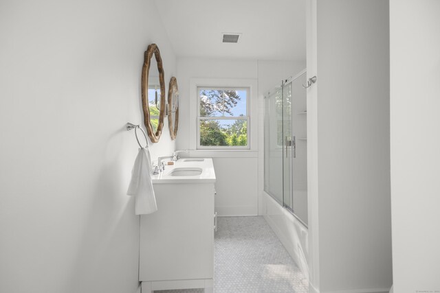 bathroom featuring enclosed tub / shower combo, vanity, and tile patterned floors