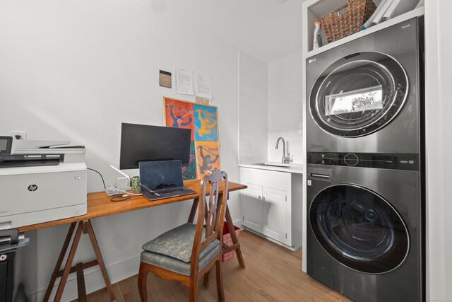 washroom with stacked washer and dryer, light hardwood / wood-style floors, and sink