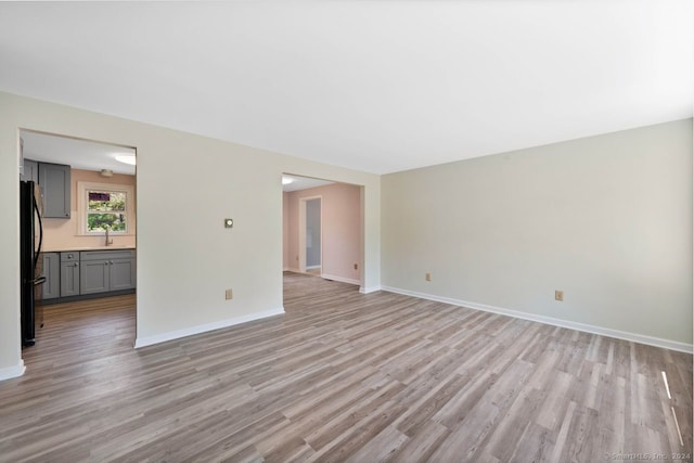 spare room featuring sink and light wood-type flooring