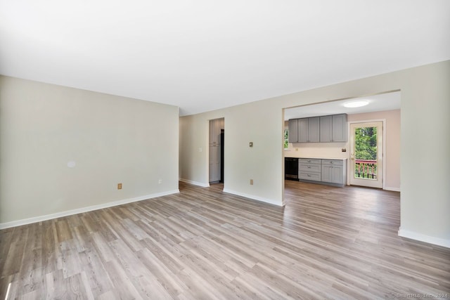 unfurnished living room with wine cooler and light hardwood / wood-style flooring