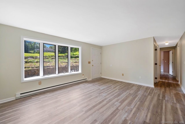 spare room featuring a baseboard radiator and light hardwood / wood-style flooring