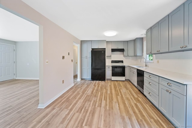 kitchen with gray cabinetry, sink, black appliances, and light hardwood / wood-style floors