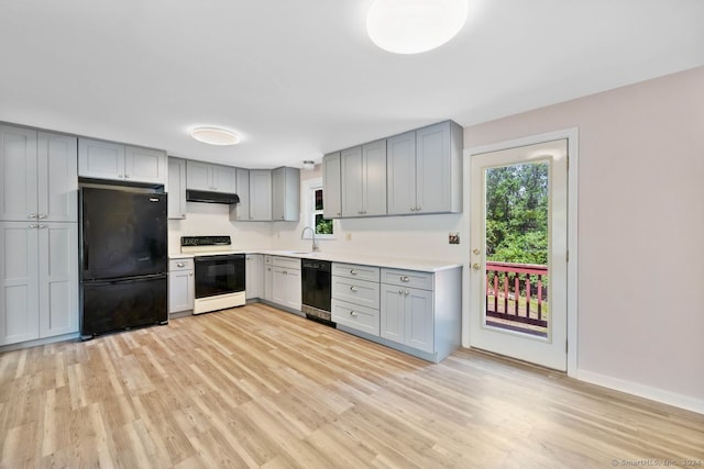 kitchen featuring light wood-type flooring, gray cabinets, sink, and black appliances