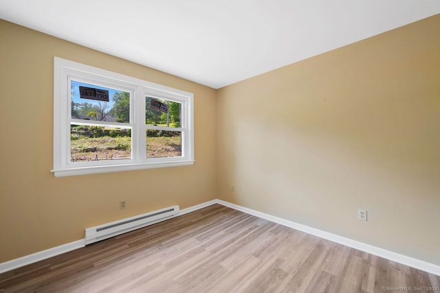 unfurnished room with a baseboard radiator and light hardwood / wood-style flooring