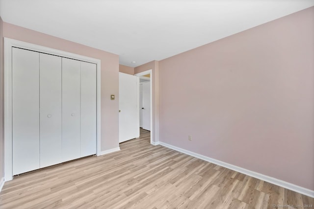 unfurnished bedroom with light hardwood / wood-style floors and a closet