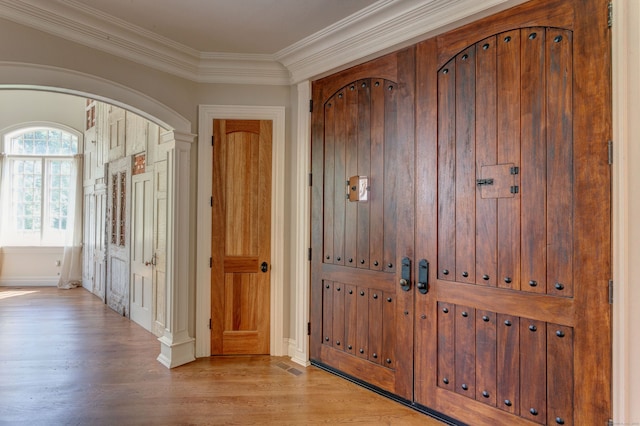 entrance foyer featuring crown molding and light wood-type flooring