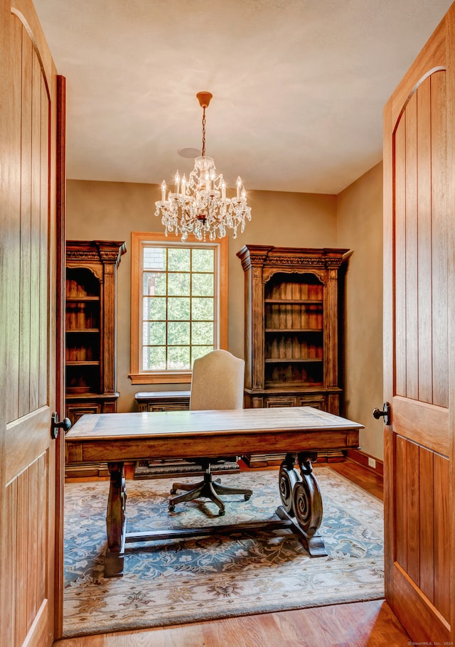 office area with light hardwood / wood-style flooring and a chandelier