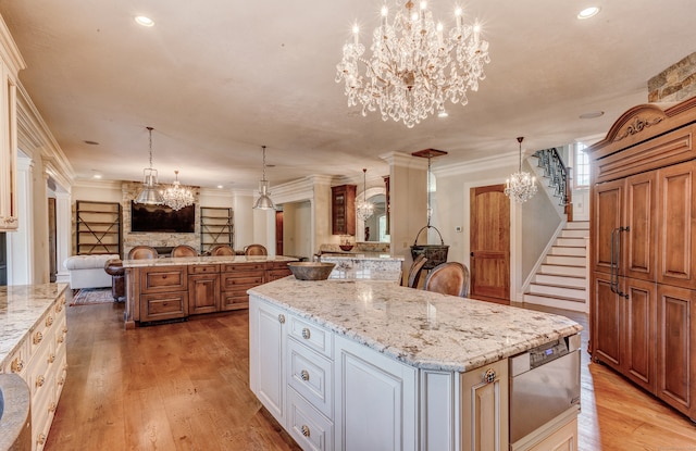 kitchen with a large island, crown molding, and light hardwood / wood-style floors