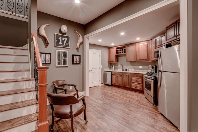 kitchen with sink, appliances with stainless steel finishes, and light wood-type flooring