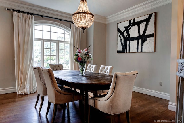 dining area featuring dark wood-type flooring, ornamental molding, and an inviting chandelier