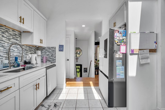 kitchen with white cabinets, light tile patterned floors, stainless steel appliances, and sink